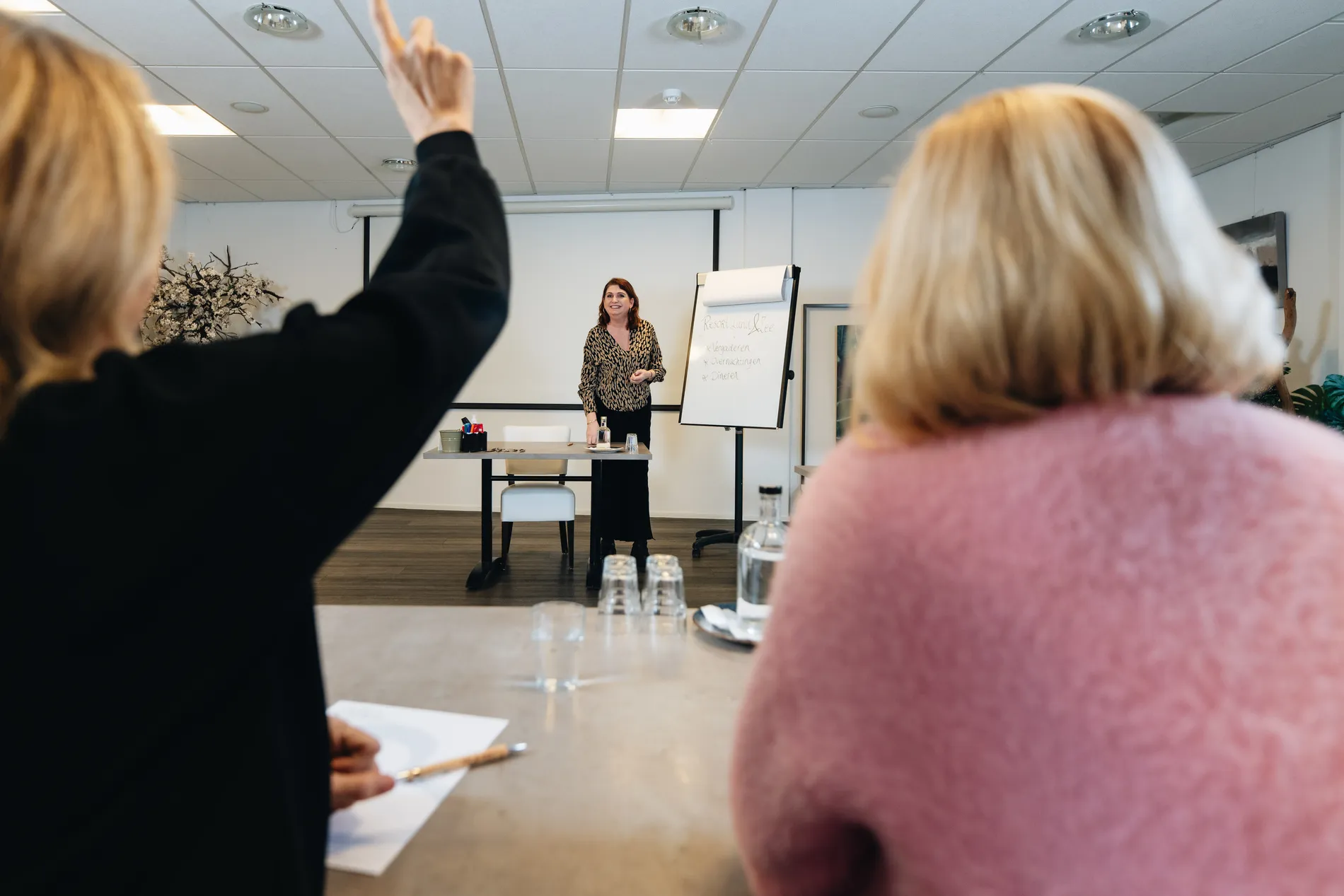 Deelnemers tijdens een zakelijke bijeenkomst of workshop in een lichte en professionele setting bij Resort Land & Zee.